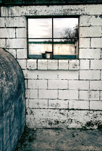 Milking Parlour Remains archival pigment print by Fred Gerendasy Photography – atmospheric photograph of an abandoned dairy barn interior with light filtering through old windows