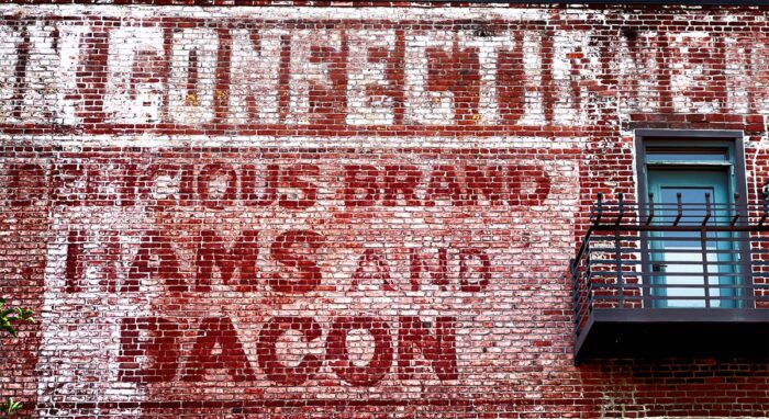 Hams and Bacon on the Brick Wall archival pigment print by Fred Gerendasy Photography – textured close-up of aged red brick with organic, abstract patterns
