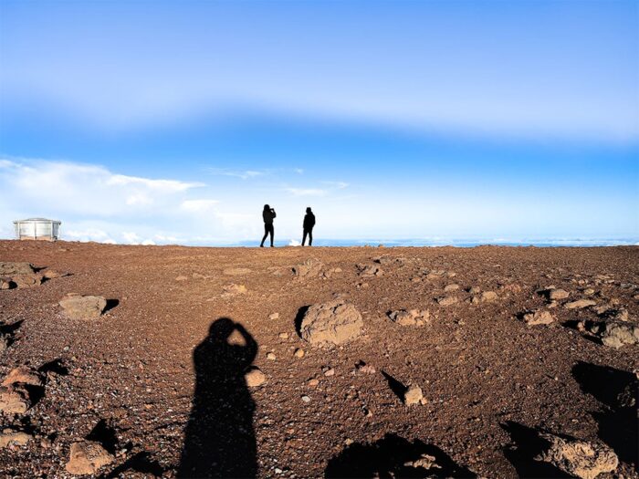 Sunrise at Haleakalā Observatory with rocky foreground and expansive cloudscape – Fred Gerendasy Photography