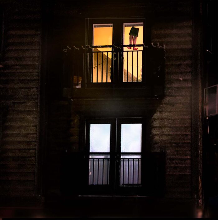 Hanging Man at night – archival pigment print by Fred Gerendasy Photography capturing window-lit urban mystery