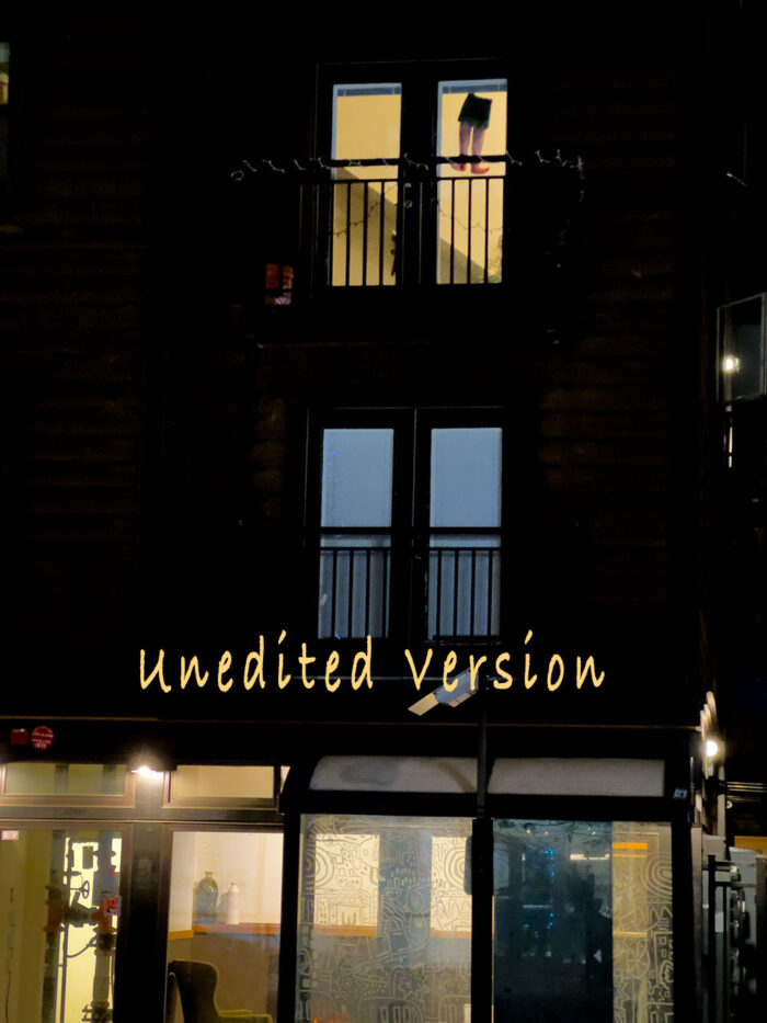 Unedited night photograph of man in window by Fred Gerendasy Photography – atmospheric urban scene with orange-tinted light