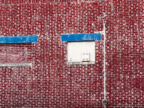 Blue on aged and sand stained red brick wall