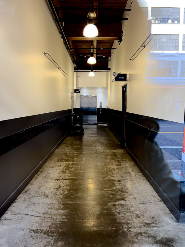 Narrow hallway off city street -Bunk Bar Sign Down Hallway