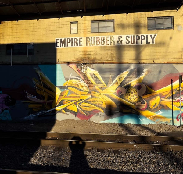 Next to the railroad tracks an old building in strong light