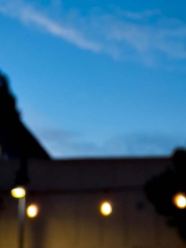 blurry photo of a darkening sky with orbs of light from the streetlamps below