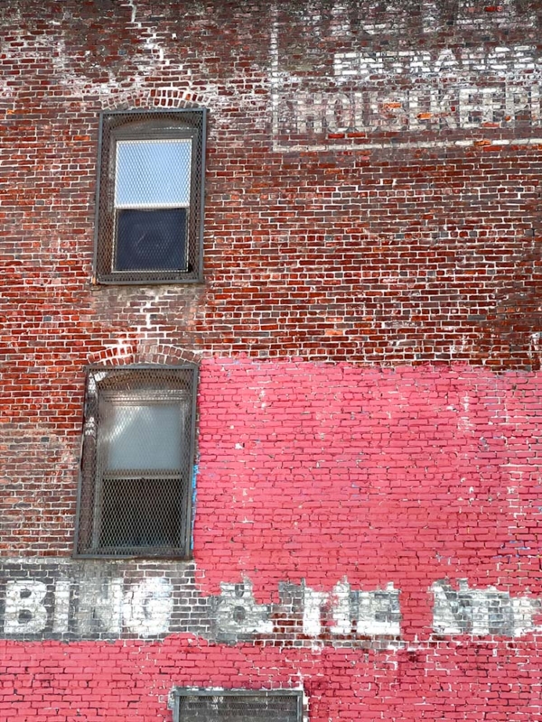 Old faded lettering on side of brick building, Bing